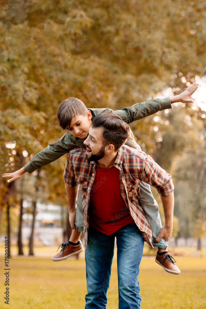 Father giving son piggyback ride Father giving son piggyback ride