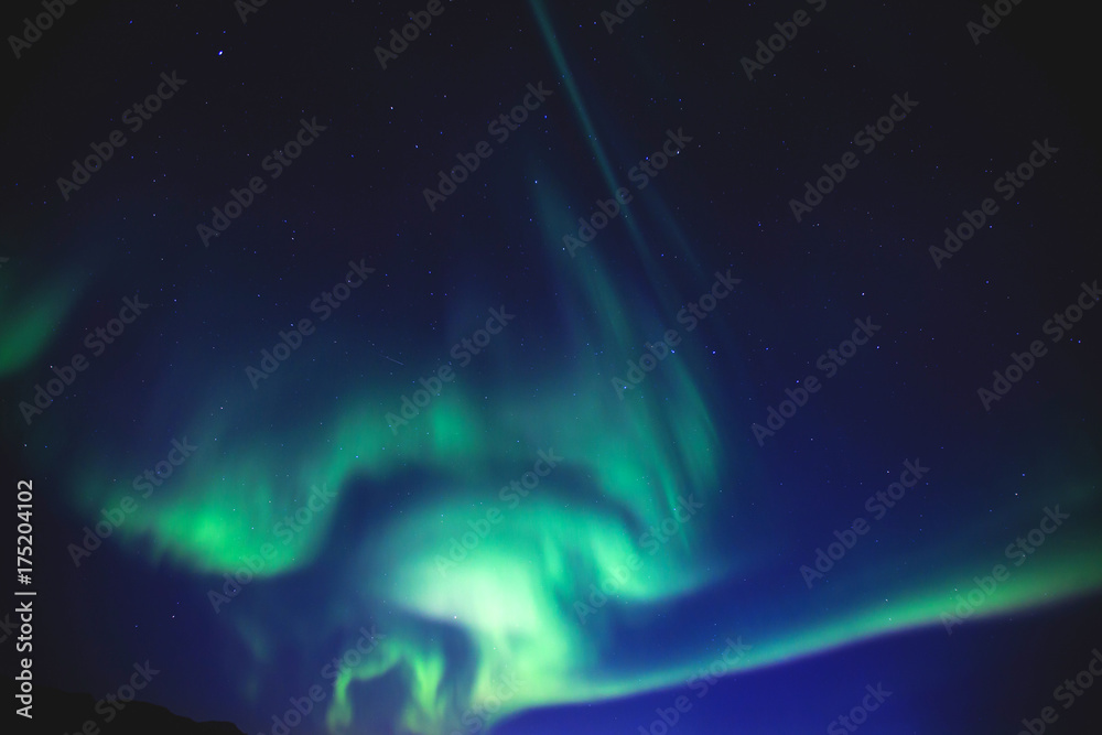 Beautiful picture of massive multicolored green vibrant Aurora Borealis, Aurora Polaris, also know as Northern Lights in the night sky over Norway, Scandinavia