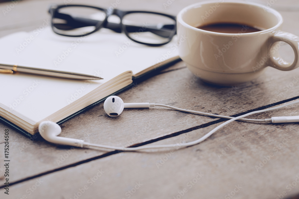 Notebook And Coffee cup are placed on wooden boards. Notebook And Coffee cup are placed on wooden boards.