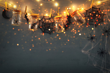 Halloween holiday concept. Masson jars with spiders, baths and wooden decorations