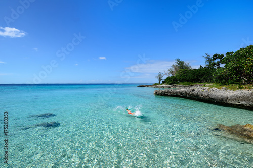 Tourist swimming in turquoise waters of the Caribbean sea on the wild noon coast of Cuba