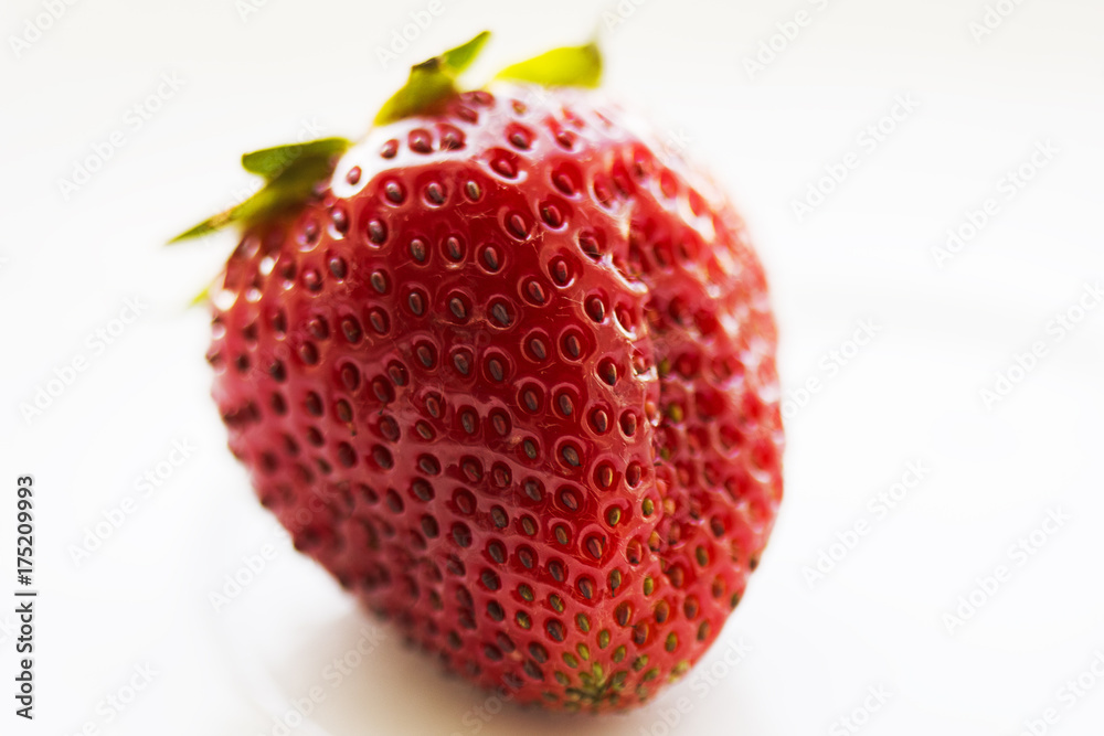 Ripe strawberries on a white background with large grains on the shell. Ripe strawberries on a white background with large grains on the shell.