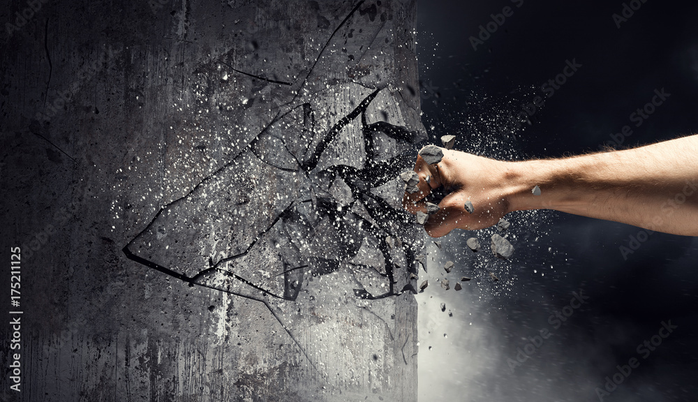 Naklejka premium Hand breaking through the wall. Mixed media