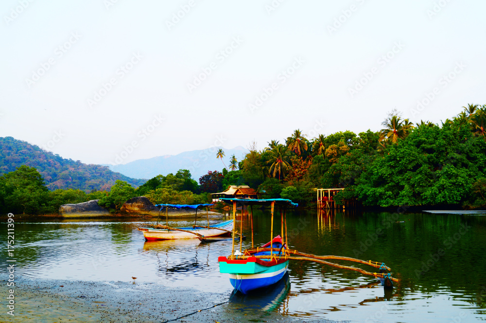 Traditional indian boat near Paloem beach. Small lagoon on the sunset. Excursion boat on the shore.
