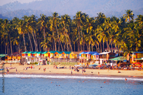 Palolem beach, South Goa, India. One of the best beaches in Goa. Colorful beach huts and palm trees on the coast. Luxury leisure.