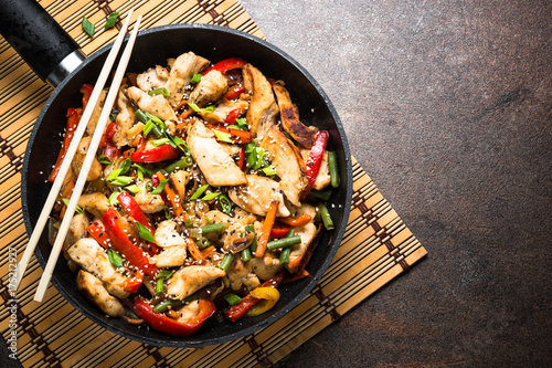 Photos Chicken stir fry with vegetables at stone background