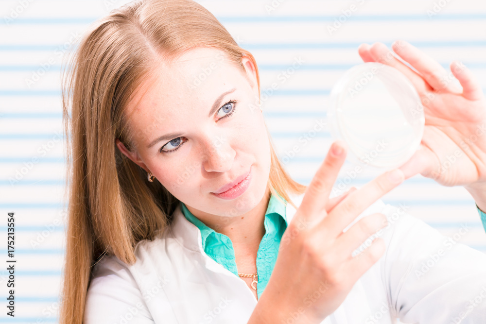 A nurse in the hospital's laboratory analyzes petri dishes A nurse in the hospital's laboratory analyzes petri dishes