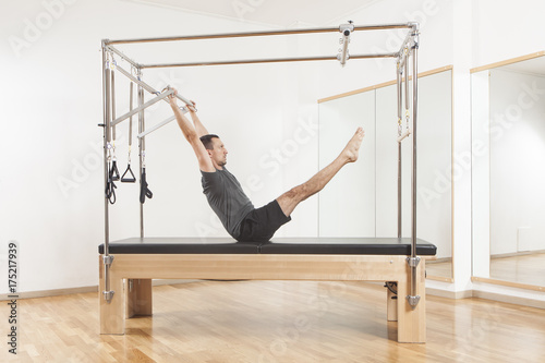 Cuadro en lienzo Pilates instructor performing exercise on cadillac equipment