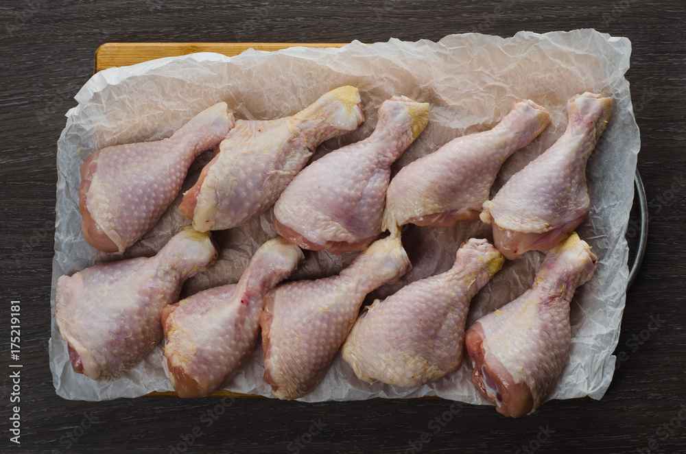 Fresh raw chicken legs arrangement on kitchen cutting board