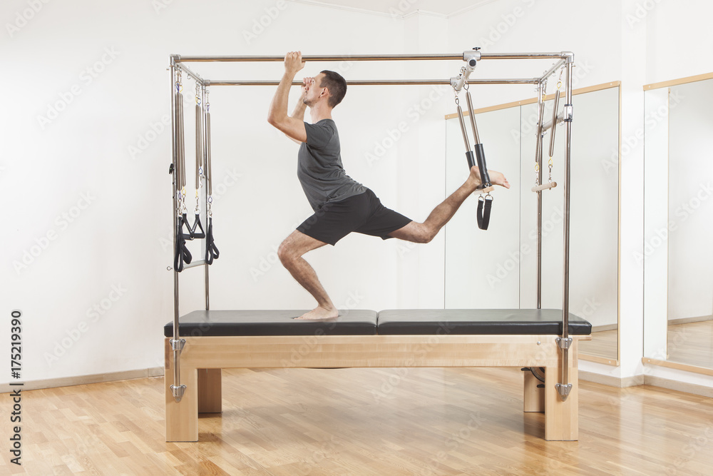 Obraz premium Pilates instructor performing exercise on cadillac equipment