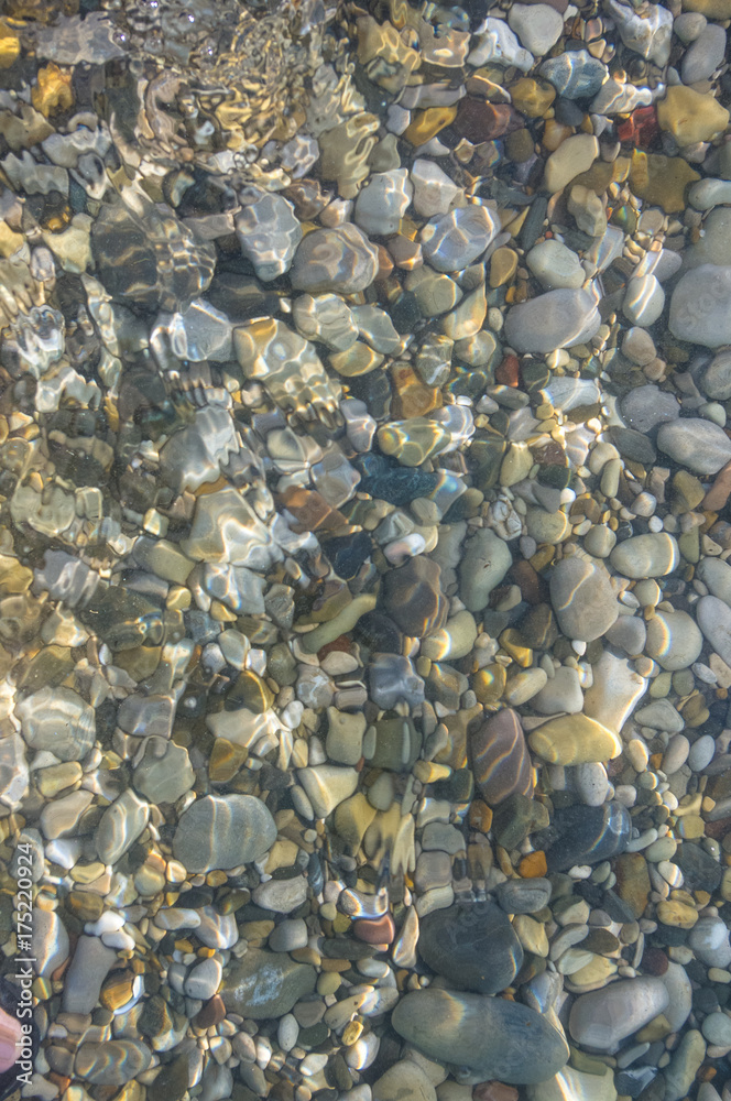 sea pebble beach with multicoloured stones, waves with foam sea pebble beach with multicoloured stones, waves with foam