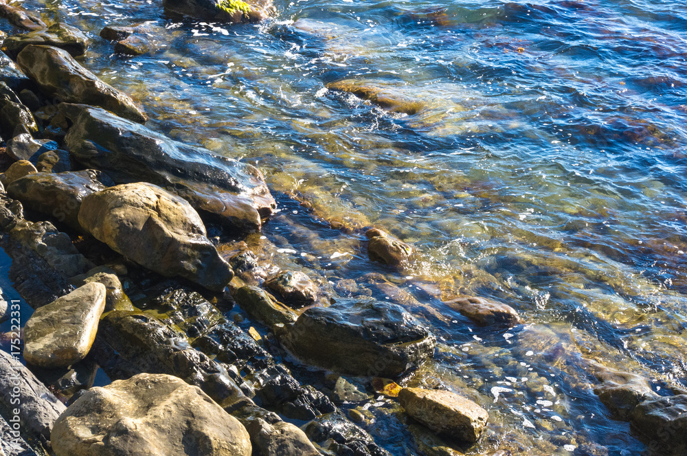 rocky sea shore with pebble beach, waves with foam rocky sea shore with pebble beach, waves with foam