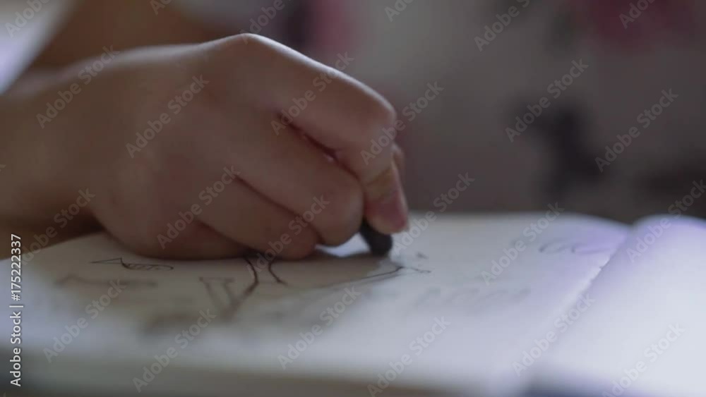 Close up of small kid erasing drawing with rubber on white paper Close up of small kid erasing drawing with rubber on white paper
