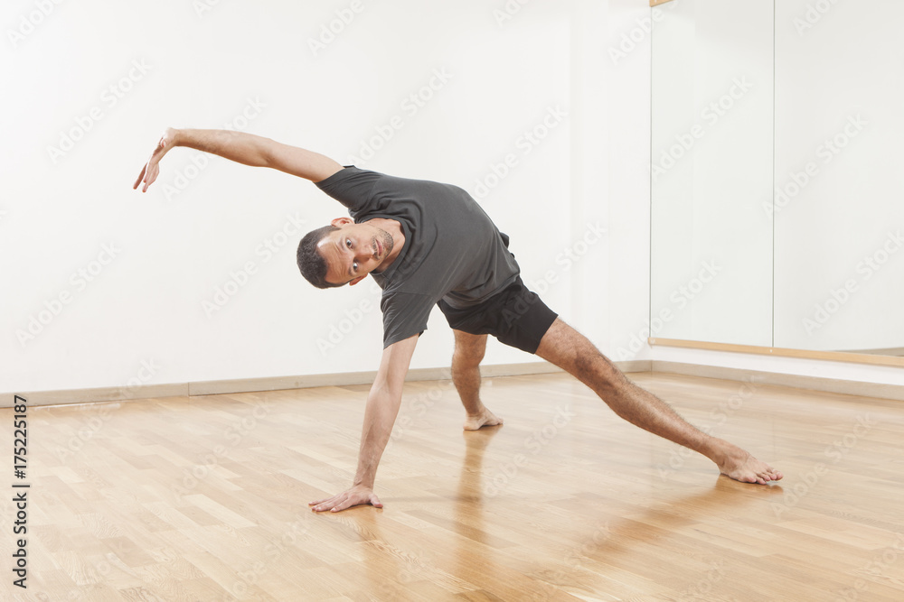 Naklejka premium Pilates instructor performing fitness exercise at the gym indoor