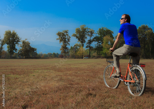 a man exercises on a bicycle /a healthy lifestyle of a fifty-years-old man practicing cycling in a park