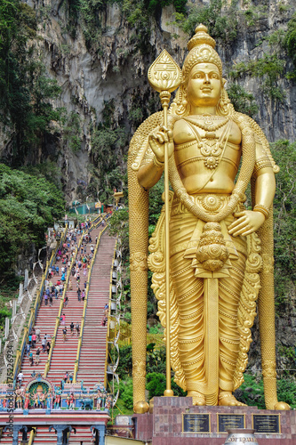 Indian tourists visit to Batu Caves in Malaysia. Main entrance with stairs and the Lord Murugan statue
