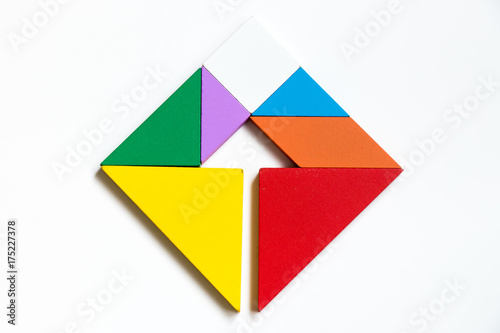 Color wood tangram puzzle on square with arrow sign shape on white background (Concept of Business direction, company vision or target)