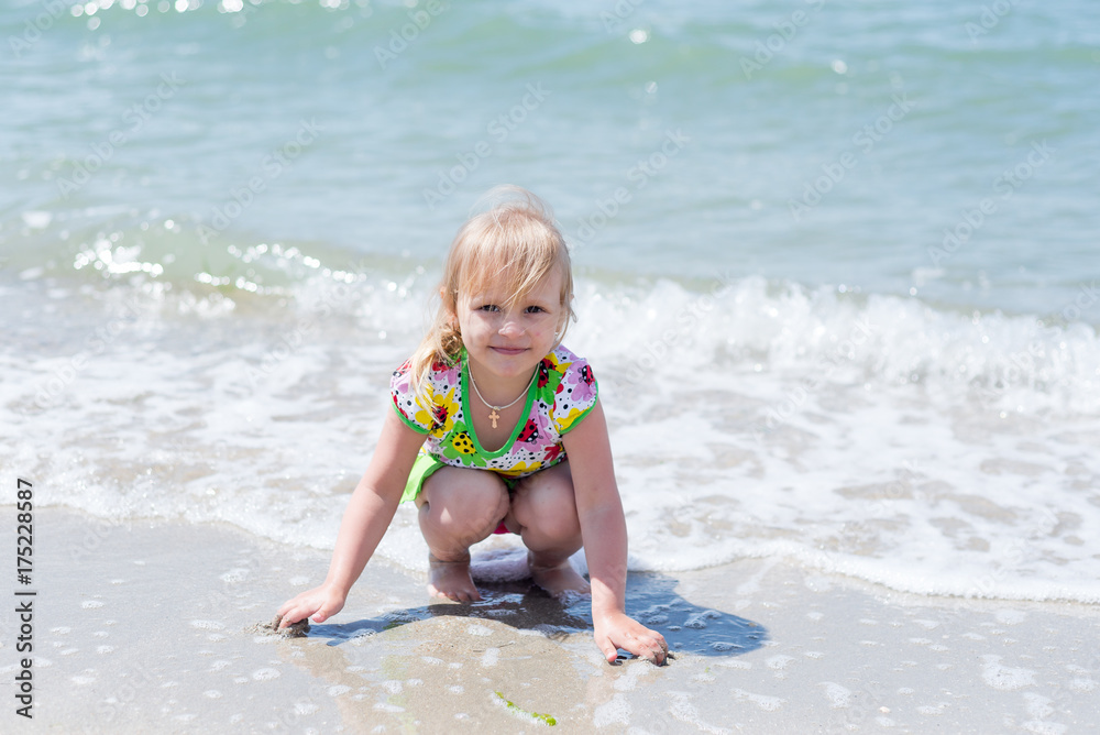 A child, a little girl playing fun on the seashore in the summer. A child, a little girl playing fun on the seashore in the summer.