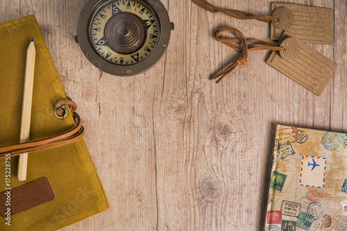 Overhead view of items to plan a trip on a rustic wooden table with copy space. Travel planning concept.