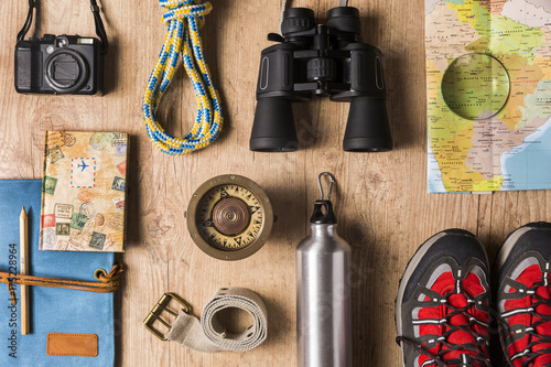 Overhead view of travel equipment for a backpacking trip on wooden floor. Adventure travel concept.