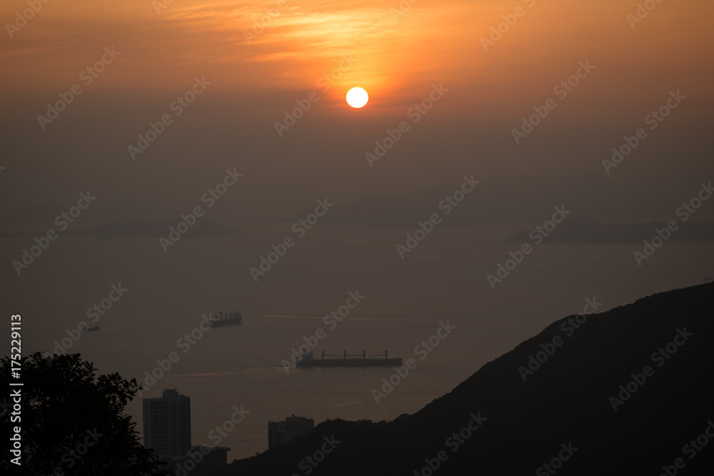 Naklejka premium Ocean, ships, coastline and sunset in Hong Kong, China, viewed from the Victoria Peak.