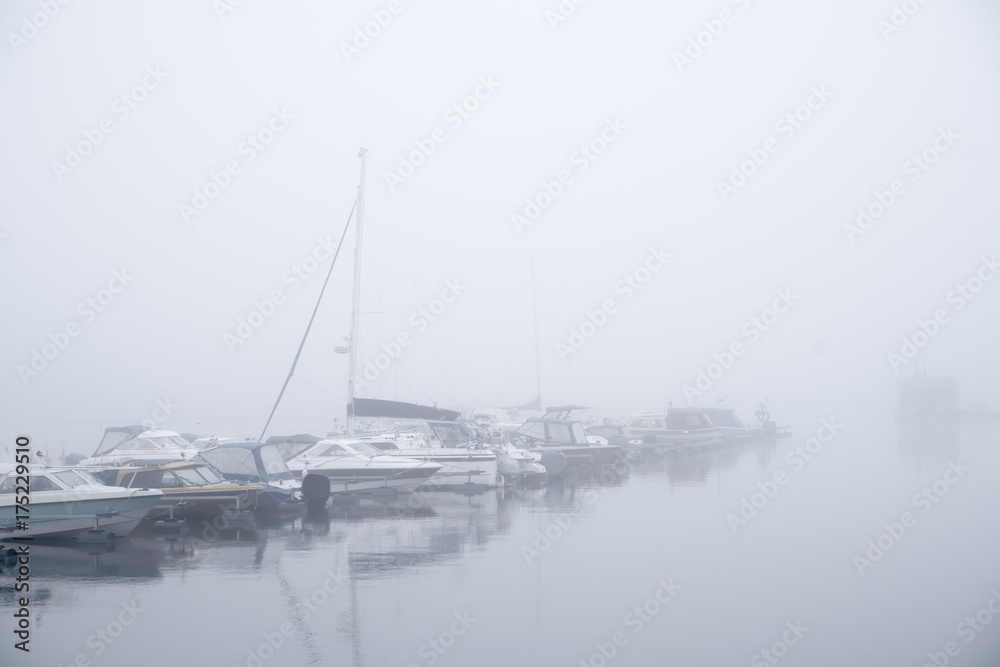 Boats in a foggy harbour in Kuopio, Finland