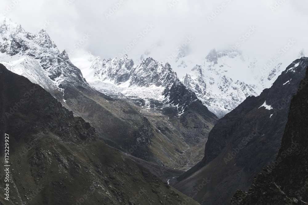 Snow mountain peaks of Caucasus mountains in cold cloudy weather, Elbrus Region. Main caucasian ridge