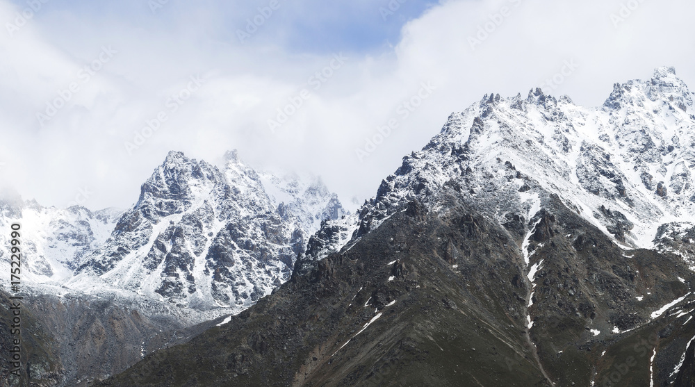Obraz premium Snow mountain peaks of Caucasus mountains in cold cloudy weather, Elbrus Region. Main caucasian ridge