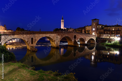 roman empire ancient bridge Ponte Pietra over the river Adige in Verona, Italy during sunset with illuminated old town