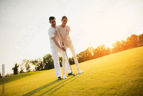 Romantic date on the golf course. Couple learning to play golf