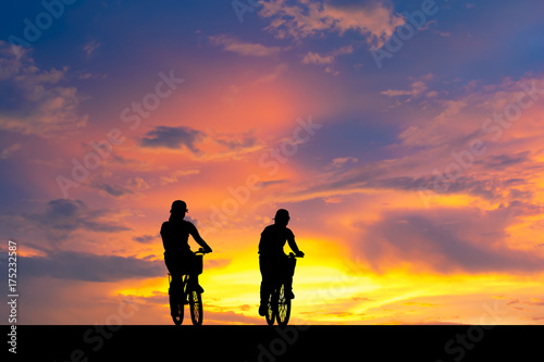 Silhouette image. Shadow of woman riding bike.