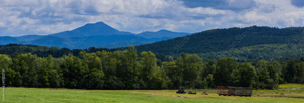 banner photo of field being mowed with Camel's Hump Mountain in Vermont in the background
