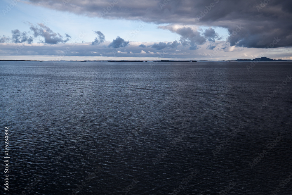 Sunset at the sea with smooth water and dramatic cloudy sky Sunset at the sea with smooth water and dramatic cloudy sky