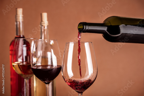 Red wine poured into glass from bottle with copyspace