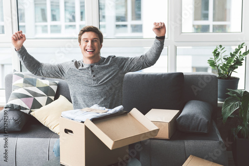 Glad male waving arms in apartment