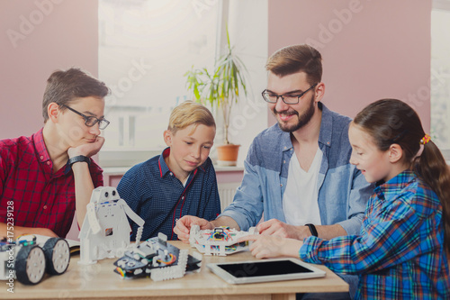 Stem education. Kids creating robots with teacher