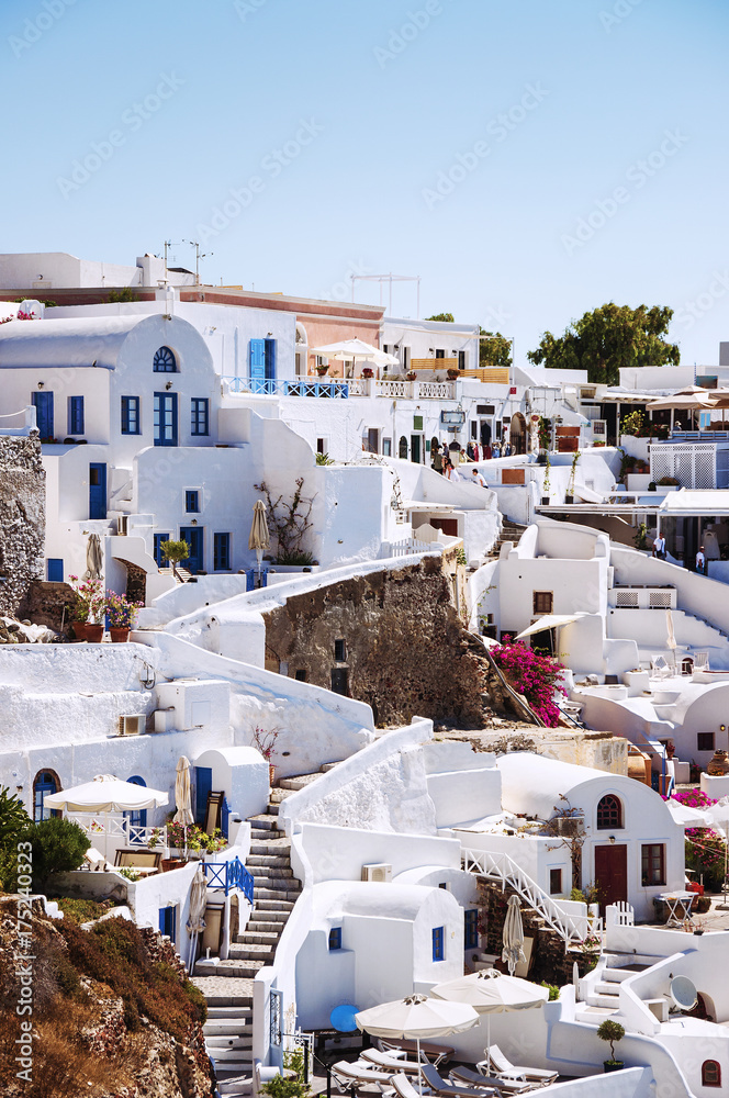 Fototapeta premium Santorini Island, Greece, Europe. Traditional white Greek architecture over Caldera, a beautiful landscape with a blue sky and famous white houses and churches.