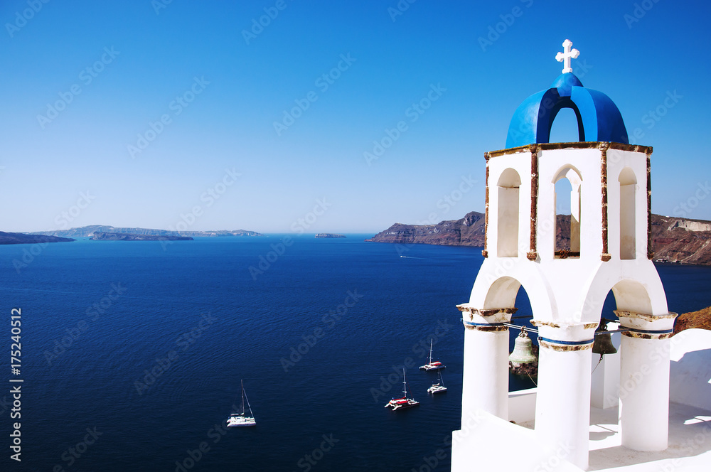 Santorini Island, the city of Oia, Greece. Traditional Greek architecture, white houses and churches with blue domes above Caldera, Aegean Sea.