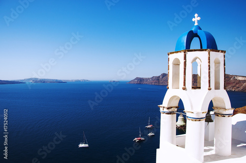 Santorini Island, the city of Oia, Greece. Traditional Greek architecture, white houses and churches with blue domes above Caldera, Aegean Sea.