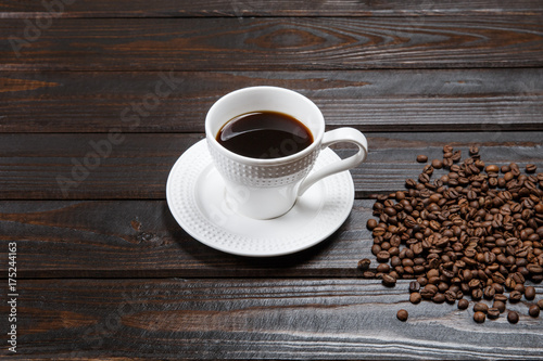 Coffee mug and coffee beans on a brown vintage table.