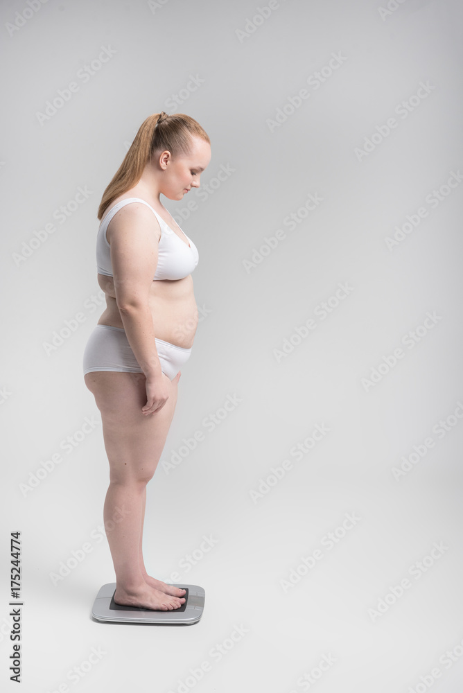 Fototapeta premium Woman standing on scales