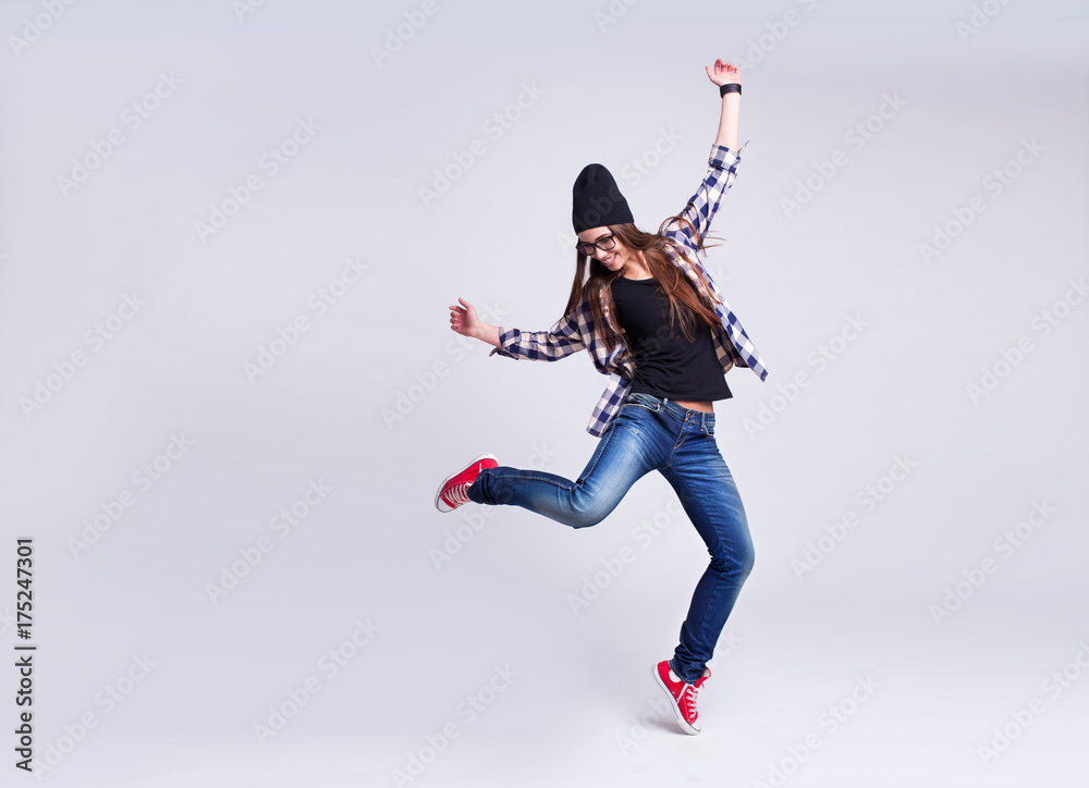 Dancing hipster girl in glasses and black beanie