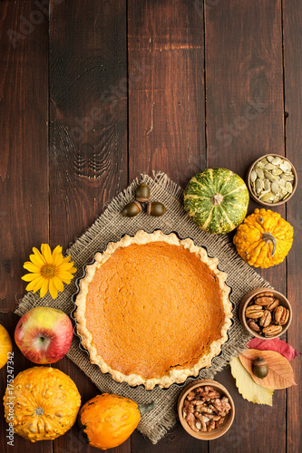 pumpkin homemade pie at wooden background arranged with food ingredients top view