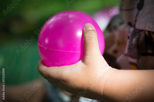 close up hand baby girl holding color ball