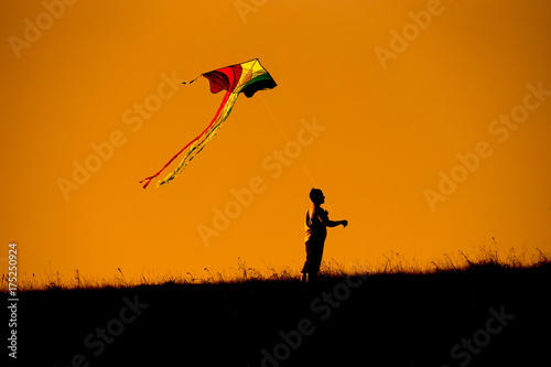 Silhouette of people flying a kite top of mountain sunset evoke emotion happy memories. Doi Mon Jong Chiang Mai Thailand.