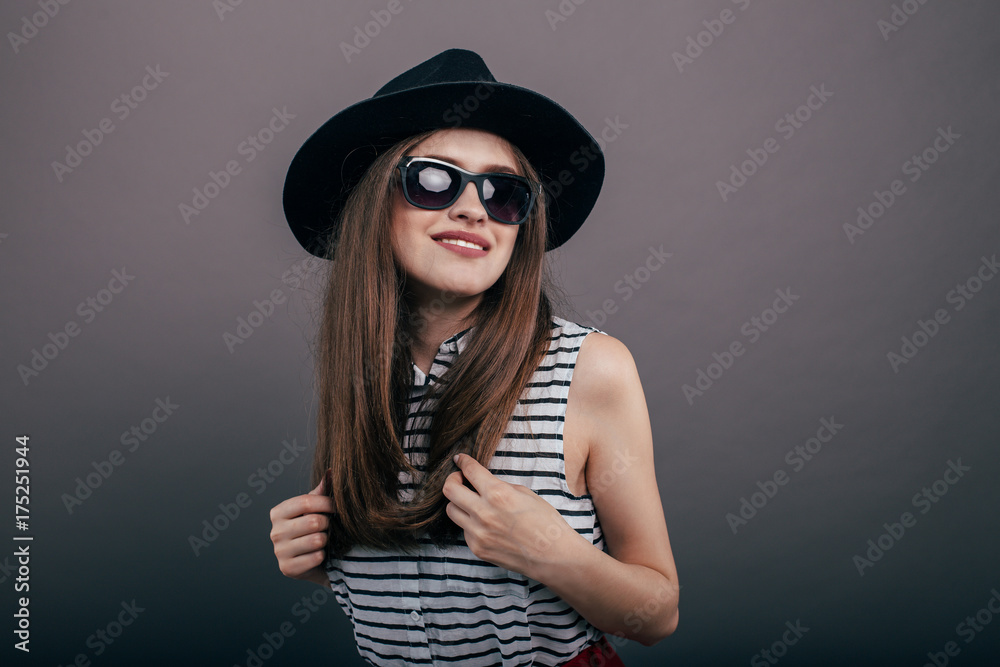 Young beautiful fashionable woman with trendy makeup in black hat and glasses on the grey background . Model looking at camera, wearing stylish eyeglasses. Female fashion, beauty concept.
Young beautiful fashionable woman with trendy makeup in black hat and glasses on the grey background . Model looking at camera, wearing stylish eyeglasses. Female fashion, beauty concept.