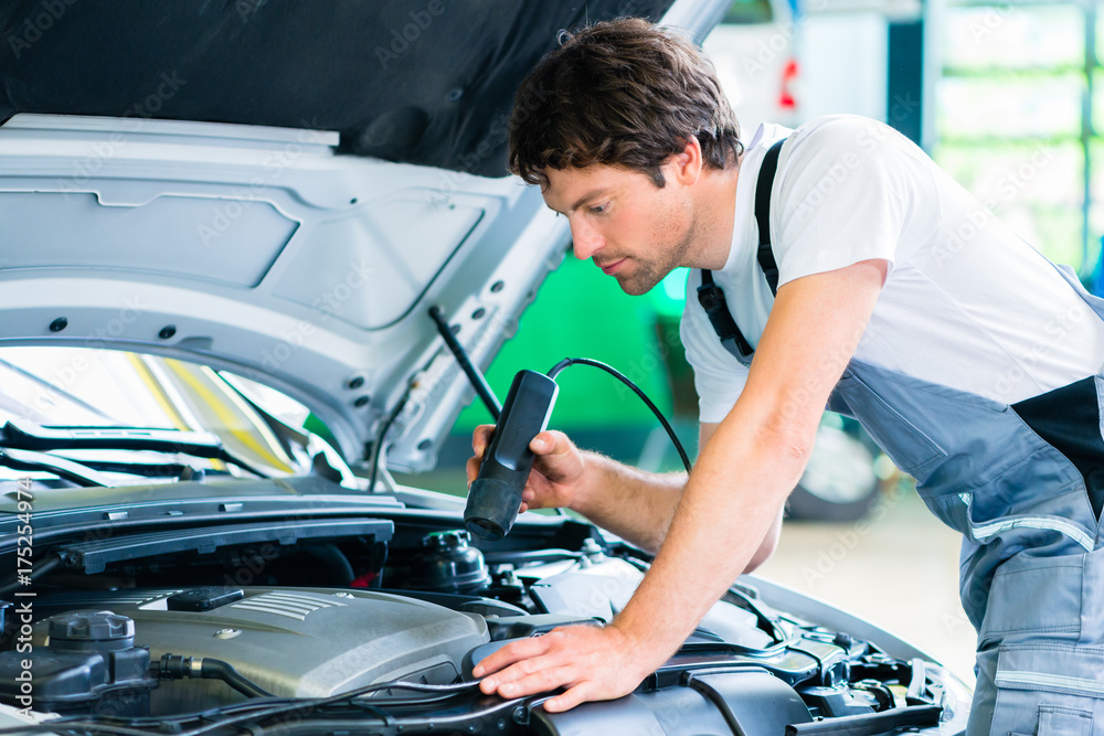 Mechanic man with diagnostic tool in car workshop Mechanic man with diagnostic tool in car workshop
