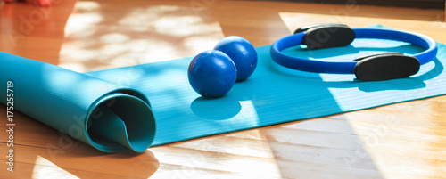 Yoga mat and exercise weights on wooden floor photo