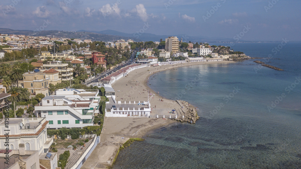 Vista aerea della costa presso il comune di Santa Marinella, vicino Roma, in Italia. In spiaggia non ci sono ombrelloni e poche persone fanno il bagno in mare.