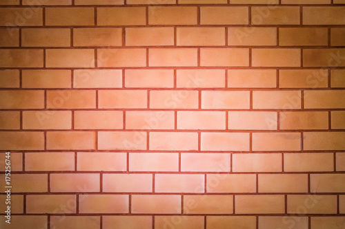 Brick wall with orange stain  light in the middle for background or wallpaper.